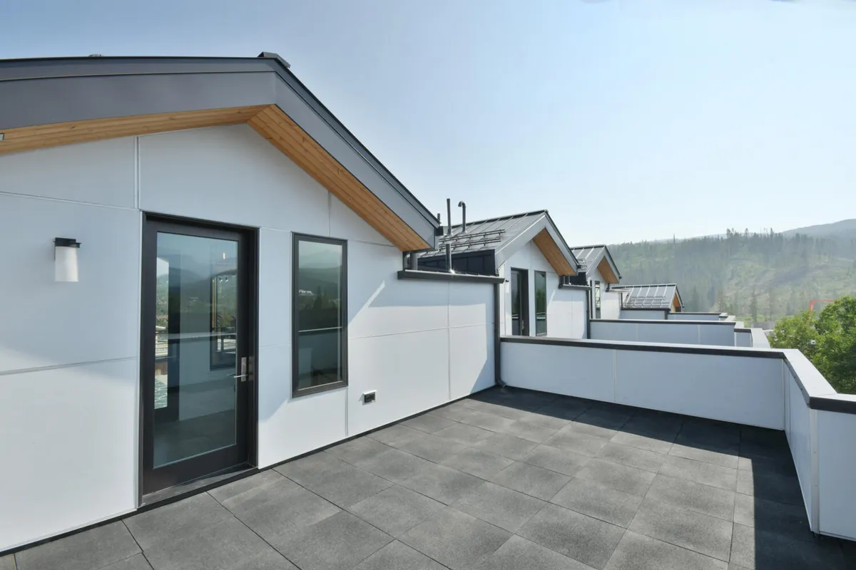 A contemporary rooftop deck with clean lines and expansive mountain views, offering space for morning coffee, gatherings, or quiet contemplation. The deck’s open design places the stunning scenery front and center.
